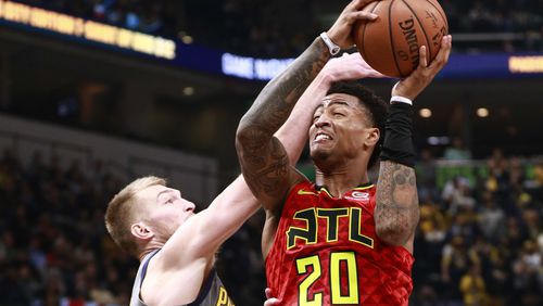 Indiana Pacers forward Domantas Sabonis (left) fouls Hawks forward John Collins as he attempts to shoot. (AP Photo/R Brent Smith)