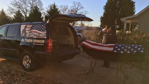 An American flag is placed on a deceased military veteran, who is seen being saluted before being placed in a vehicle for In Their Honor Transports. PROVIDED BY DON WARE