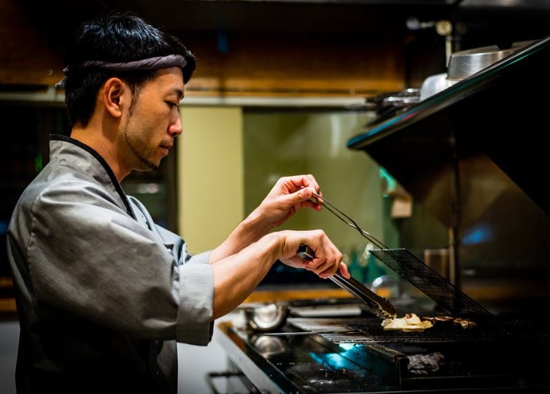Chef Takashi Otsuka at the robata grill in his restaurant Chirori. CONTRIBUTED BY HENRI HOLLIS