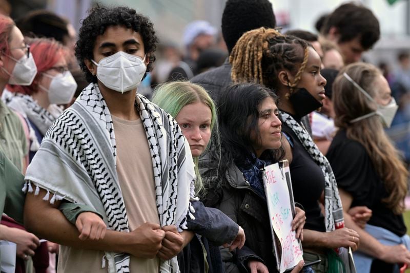 Demonstrators lock arms after crossing breeched barricades around a pro-Palestinian encampment at MIT, Monday, May 6, 2024, in Cambridge, Mass. Protesters crossed the barricades to join other pro-Palestinian demonstrators who'd been given a deadline to leave the encampment. (AP Photo/Josh Reynolds)