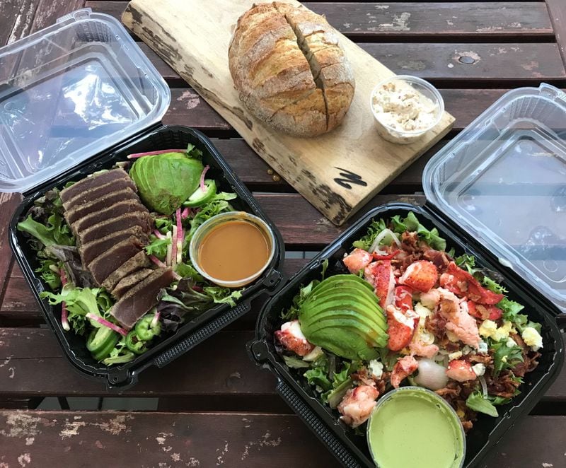 Paces & Vine offers fresh, hearty salads, including a seared ahi tuna salad (left) and a Maine lobster Cobb (right). Its freshly baked sourdough loaves come with a compound butter, whose flavors rotate daily. Ligaya Figueras / ligaya.figueras@ajc.com