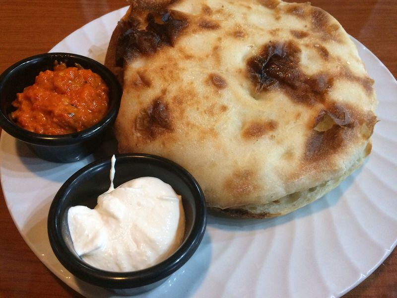 The sudzukice and cevapcici sausage combo at Euro Gourmet Grill in Lawrenceville comes with roasted red pepper sauce (ajvar) and a whipped sour cream and ricotta (kajmak). The sausages lurk inside the pita bun. CONTRIBUTED BY WENDELL BROCK