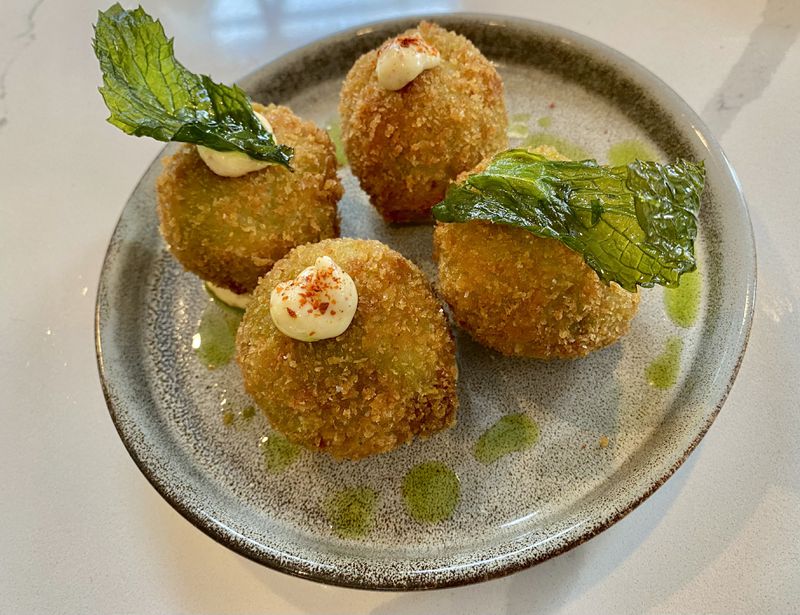 Bastone's arancini combine two traditional fillings - cheese and ciccioli - in a cheesy, meaty and spicy rice ball.  Ligaya Figueres/ligaya.figueras@ajc.com