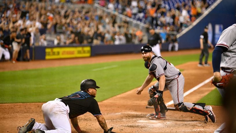 Harold Ramirez of the Miami Marlins scores the game-winning run in the 10th inning against the Braves. (Photo by Mark Brown/Getty Images)