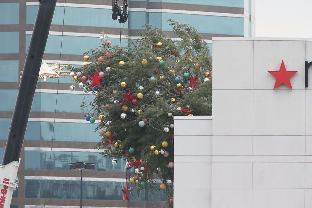 Crane buckles, leaving Christmas tree hanging off roof