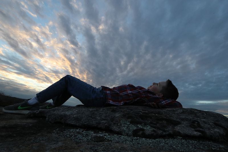 Jayden Smith, 9, of Covington takes in the sky at sunset from a granite outcropping near the top of the Arabia Mountain Trail southeast of Atlanta near Lithonia. The PATH Trails network meanders through rock outcroppings, colorful wildflower fields, rushing streams, and towering pines from the Mall at Stonecrest into Panola Mountain State Park and beyond featuring 7,000 acres of green space and Arabia Mountain. CURTIS COMPTON/CCOMPTON@AJC.COM