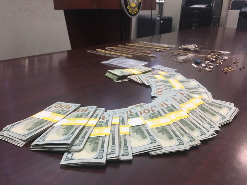 Authorities laid out $27,000 during Friday's news conference, a fraction of what they said was recovered from two homes during the arrests of four burglary suspects.