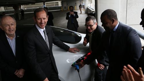 From left, Don Francis, of Clean Cities Georgia; Paul Bowers, CEO of Georgia Power; Tim Echols, of the Georgia Public Service Commission; and Atlanta Mayor Kasim Reed after plugging in a vehicle at a new charging station at the Atlanta airpiort’s international terminal. (HENRY TAYLOR / HENRY.TAYLOR@AJC.COM)
