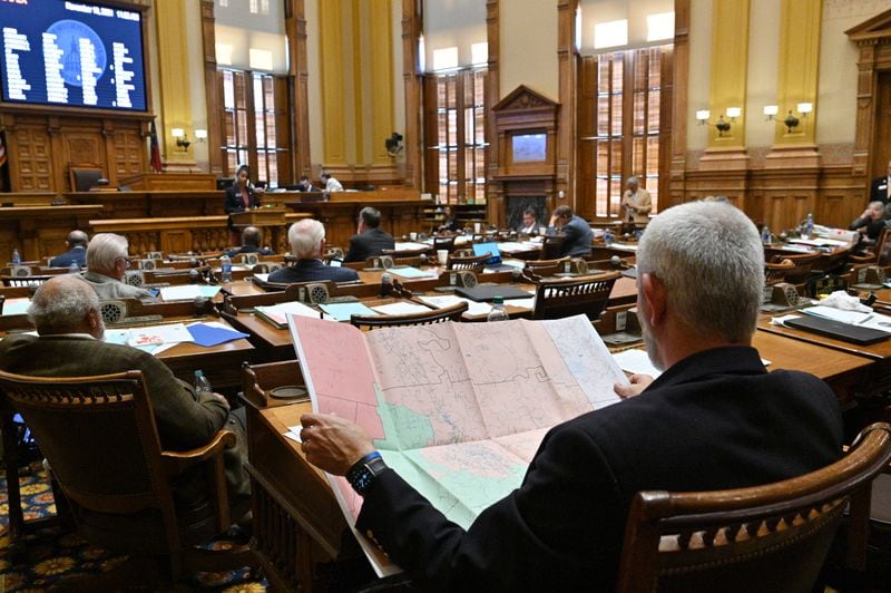 November 19, 2021 Atlanta - Chuck Payne (R-Dalton), foreground, looks at a map as Nikki Merritt (D-Grayson), background, speaks in opposition of SB 2 EX, newly-drawn congressional maps, in the Senate Chambers during a special session at the Georgia State Capitol in Atlanta on Friday, November 19, 2021. (Hyosub Shin / Hyosub.Shin@ajc.com)