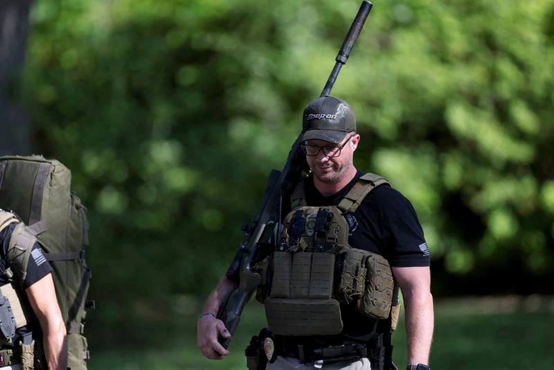A law officer walks away from the scene of a shooting where multiple law enforcement officers were shot while serving a warrant for a felon wanted for possessing a firearm in Charlotte, N.C., on Monday, April 29, 2024. (Khadejeh Nikouyeh/The Charlotte Observer via AP)
