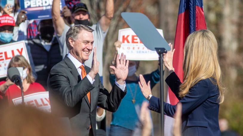 11/20/2020 �  Canton, Georgia �Senator David Perdue (left) and Senator Kelly Loeffler (right) exchange a high-five as they take turns speaking to the crowd gathered during a Defend the Majority Republican Rally in Canton, Ga., Friday, November 20, 2020.  (Alyssa Pointer / Alyssa.Pointer@ajc.com)