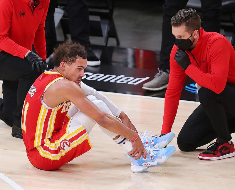 Hawks guard Trae Young grabs his ankle after falling during the third quarter of Game 3 of the Eastern Conference finals against the Milwaukee Bucks Sunday, June 27, 2021, at State Farm Arena in Atlanta. (Curtis Compton / Curtis.Compton@ajc.com)