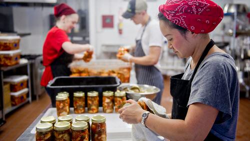 Hannah Chung (right) dries jars of kimchi at the Simply Seoul Kitchen in Decatur in 2014. / AJC file photo