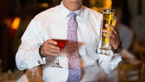 September 15, 2015 - Atlanta, Ga: A waiter carries alcoholic drinks to a table in the main level dining area at Hal's Steakhouse Tuesday, September 15, 2015, in Atlanta, Ga. All the waiters wear white shirts and ties. This part of a multi-piece cover story on some of the best restaurants in the northern suburbs/north Atlanta. PHOTO / JASON GETZ