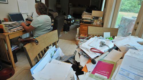 110824 Cumming : Emily Greenway checks her email as piles of mails and bills are shown in foreground at her home in Cumming on Wednesday, August 24, 2011. Greenway is an RN who filed for bankruptcy after being unable to pay off heavy credit card debt. In her bankruptcy proceeding, she will get to keep her home where she lives with her disabled husband. Hyosub Shin, hshin@ajc.com