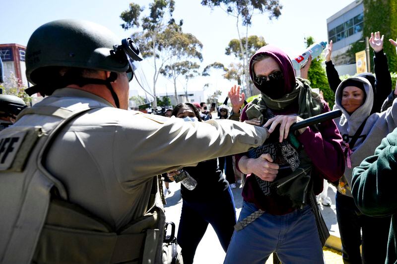 Police officers clash with Pro-Palestinian protesters at UC San Diego, Monday, May 6, 2024, in San Diego. Police cleared a campus Pro-Palestinian encampment in the early morning Monday. (AP Photo/Denis Poroy)