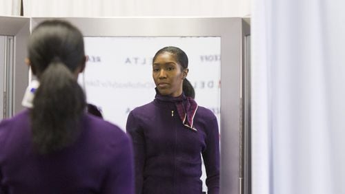 Kyandra Ravenel, a Delta airlines flight attendant, looks at herself in a mirror during the uniform fitting for Delta employees at Hartsfield-Jackson Atlanta International Airport in Atlanta, Georgia, on Wednesday, February 7, 2018. (REANN HUBER/FILE)