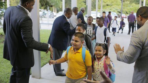 Members of the 100 Black Men of Atlanta greet students as they arrive for the first day of school at Hamilton E. Holmes Elementary in East Point on Aug. 6, 2018. BOB ANDRES /BANDRES@AJC.COM