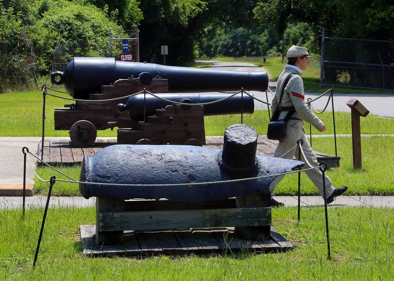 Historical interpreter Cpl. Dianna Jowers walks past cannons recovered from the CSS Georgia ironclad on display in 2013 at Fort Jackson, a National Historic Landmark and the oldest standing brick fort in Georgia on the Savannah River. The wreckage of the ship sat underwater for almost 150 years. Some material, including cannons, were removed by archaeologists decades ago. More recently, more of the wreck and related artifacts were recovered as part of a deepening project for the shipping channel. From back to front are a model 1846 32-pounder and a 24-pound howitzer. Both were mounted on the CSS Georgia during the Civil War. At front is a 10-inch columbiad -- not from the CSS Georgia. Curtis Compton / AJC 