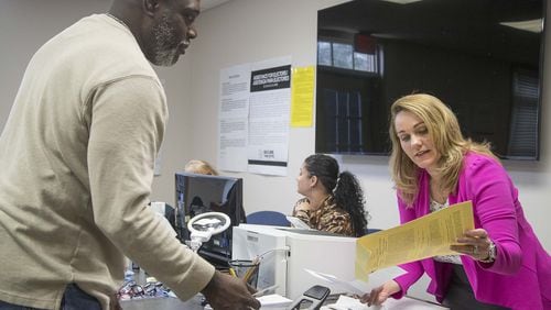 Dacula City Hall Elections Superintendent Heather Coggins (right) hands Denis Haynes Jr. a ballot during early voting for a special election for city council at Dacula City Hall in Dacula, Wednesday, March, 18, 2020. (ALYSSA POINTER/ALYSSA.POINTER@AJC.COM)