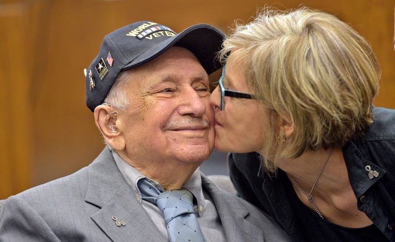 World War II Army veteran Sgt. Xenophon Doudalis gets a kiss on the cheek from Diane Anastazia, the local woman who brought Doudalis' story to the attention of the French government, which awarded him the French Legion of Honor. The City of Des Plaines hosted a French Legion of Honor ceremony for Doudalis on Friday, June 22, 2018, in Des Plaines, Ill. (Jon Langham/Pioneer Press/TNS)
