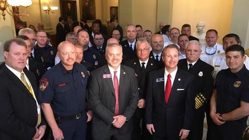 Firefighters, who watched the Senate's passage of House Bill 146, pose with bill sponsor Rep. Michah Gravley and Sen. John Albers