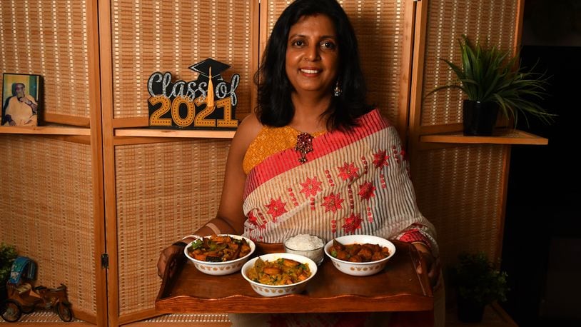 Sukanya Kar Bhowmik, who embraces her Bengali heritage by preparing traditional dishes she learned from her mother and grandmother, shows three of her dishes: (from left) Loitta Shurkir Jhal (Dry Bombay Duck Curry), Lau Chingri (Bottle Gourd Curry with Shrimp), and Chitol Macher Muithya (Bengali Fish Curry). (Styling by Sukanya Kar Bhowmik / Chris Hunt for the AJC)