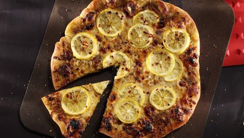 Pizza gets a smoky flavor from smoked mozzarella, which contrasts with sliced lemon and savory pesto. (Abel Uribe/Chicago Tribune/TNS)