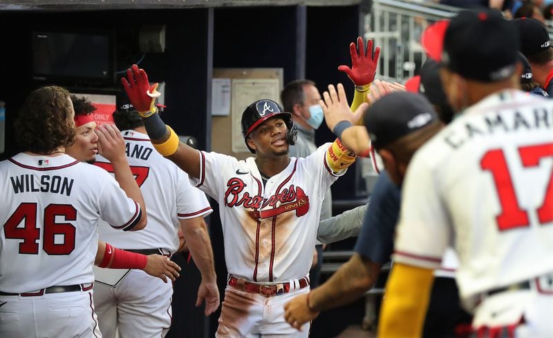 Braves outfielder Ronald Acuna gets high fives in the dugout hitting a solo home run to take a 2-0 lead over the Toronto Blue Jays during the third inning in a MLB baseball game on Tuesday, May 11, 2021, in Atlanta.    “Curtis Compton / Curtis.Compton@ajc.com”