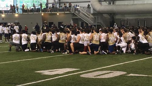 Participants at Georgia Tech coach Geoff Collins' showcase camp listen to Yellow Jackets defensive line coach Larry Knight (in bucket hat) at the Brock indoor practice facility on Monday January 3, 2019.