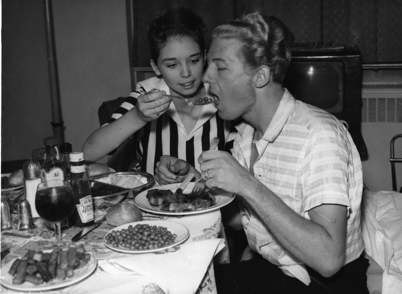 Jerry Lee Lewis and his 13-year-old wife Myra enjoy a meal at their room in the  Westbury Hotel in London on May 26, 1958. His engagements in Britain were canceled after only three concerts due to outrage over the marriage. (AP Photo)