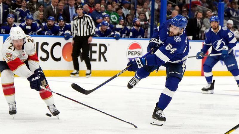 Tampa Bay Lightning center Tyler Motte (64) fires the puck for a goal against the Florida Panthers during the second period in Game 3 of an NHL hockey Stanley Cup first-round playoff series, Thursday, April 25, 2024, in Tampa, Fla. Defending for Florida is center Nick Cousins (21). (AP Photo/Chris O'Meara)