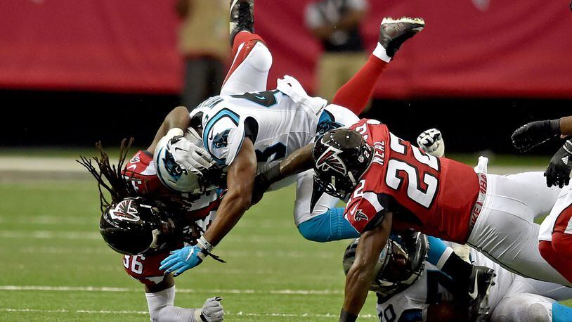Carolina Panthers running back Fozzy Whittaker is brought down by Atlanta Falcons Kemal Ishmael and Keanu Neal during the second quarter in the Georgia Dome Sunday October 2, 2016. BRANT SANDERLIN/BSANDERLIN@AJC.COM