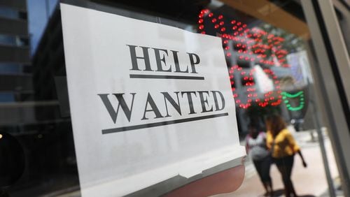 A “help wanted” sign hangs on a window of a restaurant earlier this month. Metro Atlanta’s jobless rate has slid to a 17-year low. (Photo by Joe Raedle/Getty Images)