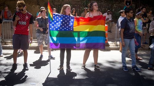 Caitlin Mussak (L) and Haley Brooks hold a rainbow flag as the Atlanta Pride Parade makes its way down 10th Street, Sunday, Oct. 9, 2016. STEVE SCHAEFER / SPECIAL TO THE AJC