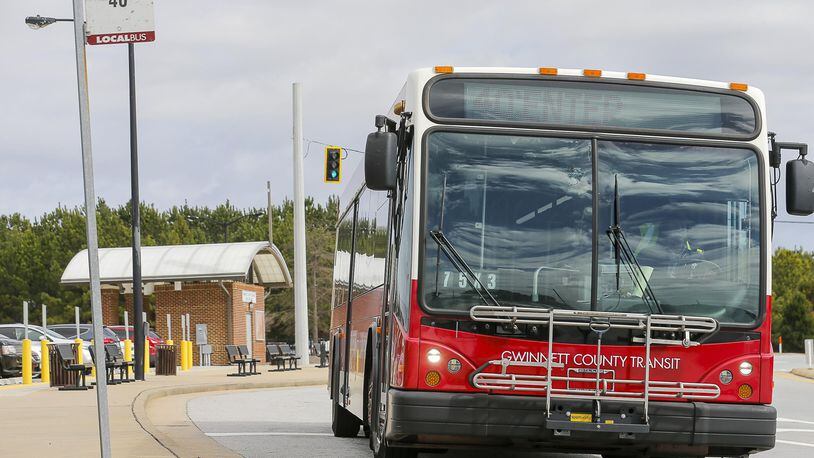 A Gwinnett County Transit bus travels along North Brown Road NW near a Gwinnett County Transit Park and Ride bus station in Lawrenceville. (ALYSSA POINTER/ALYSSA.POINTER@AJC.COM) AJC FILE PHOTO
