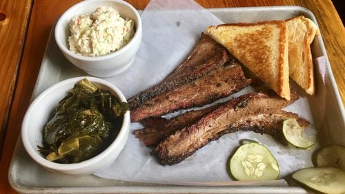 The Beef Brisket Plate from the Nest with a side of coleslaw and collard greens. The restaurant also offers plates of pulled pork, a half-chicken and chicken tenders. Each comes with two sides, house pickles and Texas toast. HOLLY STEEL / HSTEEL@AJC.COM