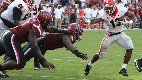 Elijah Holyfield breaks free from South Carolina defenders on his way to a touchdown and a 41-10 lead during the third quarter in a NCAA college football game on Saturday, Sept 8, 2018, in Columbia. Curtis Compton/ccompton@ajc.com