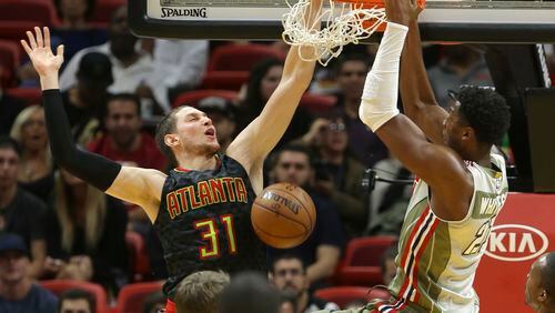 Miami Heat center Hassan Whiteside (21) dunks over Atlanta Hawks forward Mike Muscala (31) during the second half of an NBA basketball game, Tuesday, Nov. 15, 2016, in Miami. The Hawks defeated the Heat 93-90. (AP Photo/Lynne Sladky)