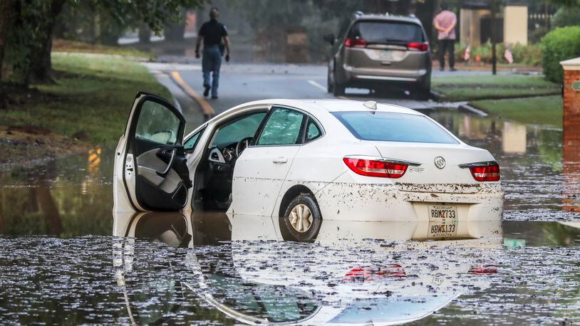 A woman who drove her car into high water was able to safely extricate herself on Columns Drive at Atlanta Country Club Drive in Cobb County on Wednesday, Sept 8, 2021 as torrential rains brought flooding and damage to Cobb County overnight. (AJC file)