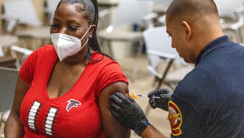 Keyonna Billingslea received her Covid booster shot by AEMT Luogo Adames during a vaccine event at Atlanta City Hall on June 25, 2022.  Steve Schaefer / steve.schaefer@ajc.com)