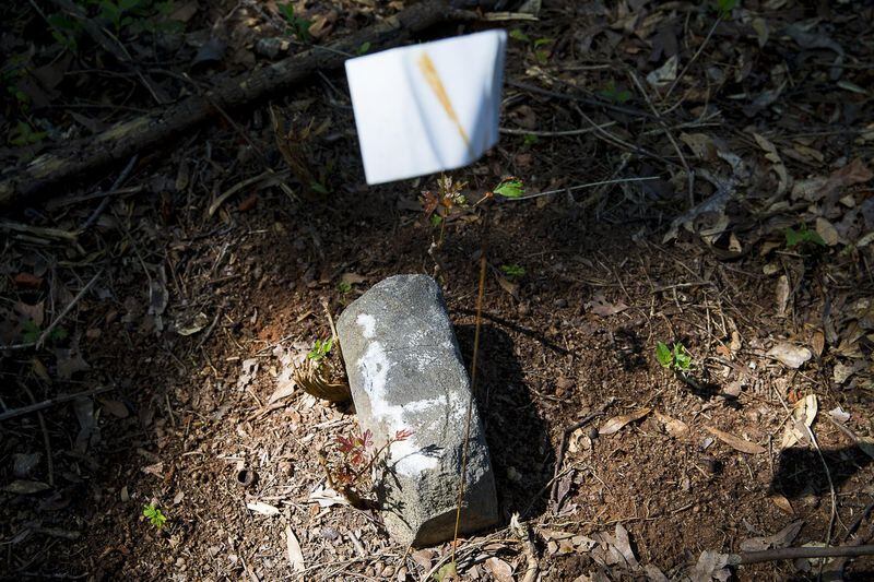 An unmarked gravestone is flagged at Old Mt. Zion cemetery in Smyrna, Friday, June 21, 2019. The city of Smyrna is taking care of a historically black cemetery on Hawthorne Road. City staff are determining how may burial sites there are and cleaning up the property. ALYSSA POINTER/ALYSSA.POINTER@AJC.COM