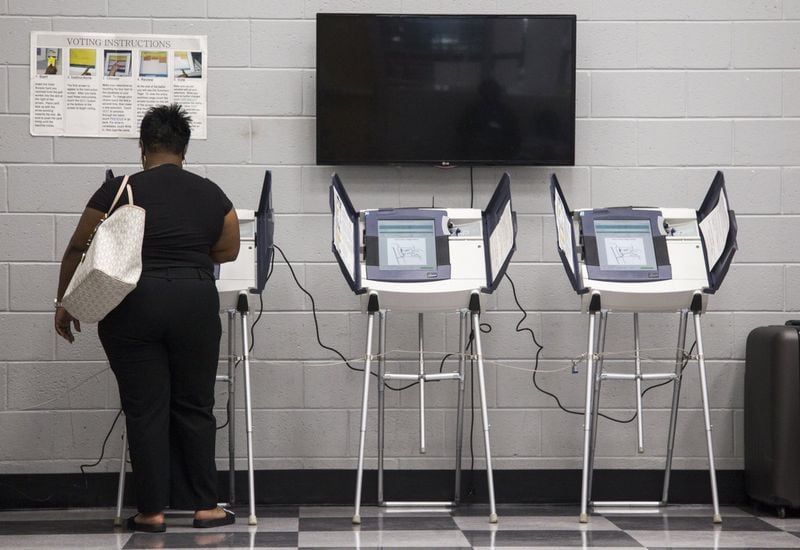 A woman casts her vote during Saturday early voting at the C.T. Martin Natatorium and Recreation Center in Atlanta in May. The state’s 27,000 touchscreen voting machines do not come with a paper backup. (REANN HUBER/REANN.HUBER@AJC.COM)