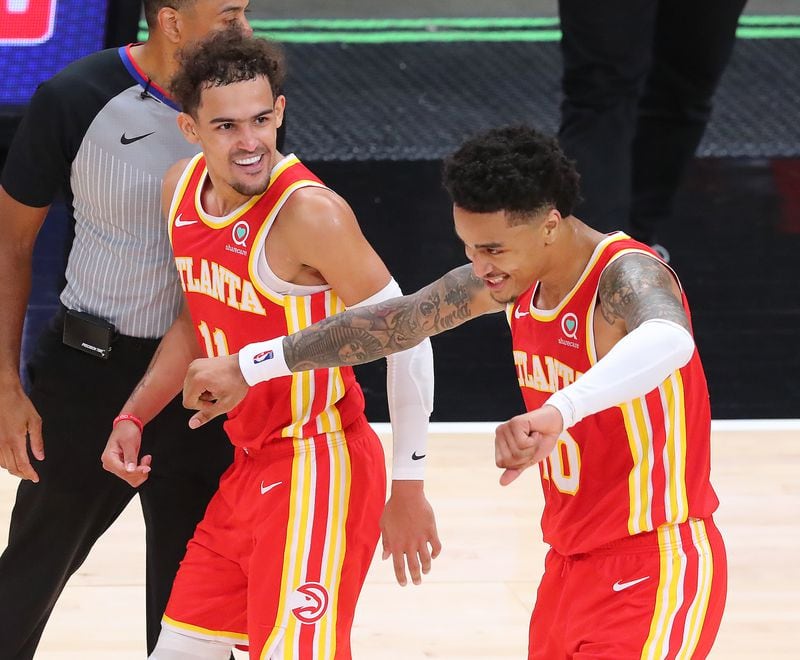 Hawks' Trae Young (left) celebrates with John Collins after Collins hit a three-pointer in the final minute.    “Curtis Compton / Curtis.Compton@ajc.com”
