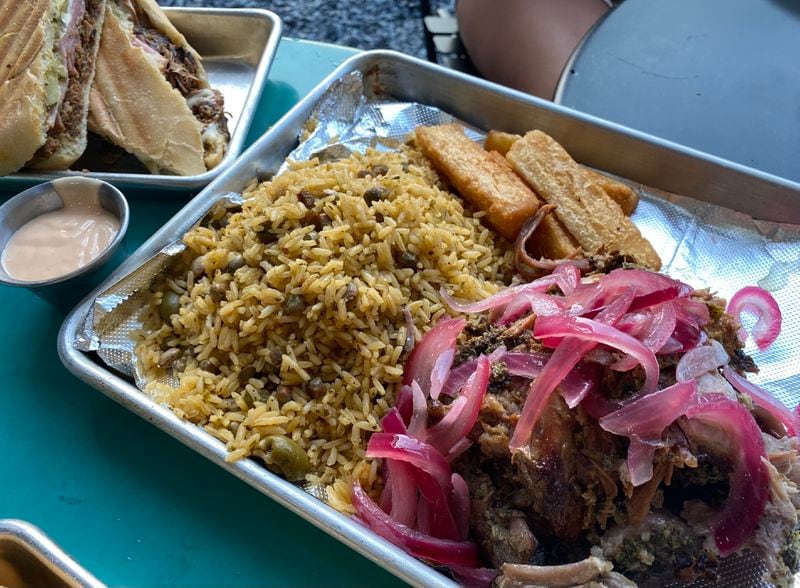 Raul's Latin Kitchen offers quintessential Puerto Rican plates like slow-roasted pork (pernil) with a side of yellow rice and peas. (Ligaya Figueras / ligaya.figueras@ajc.com)