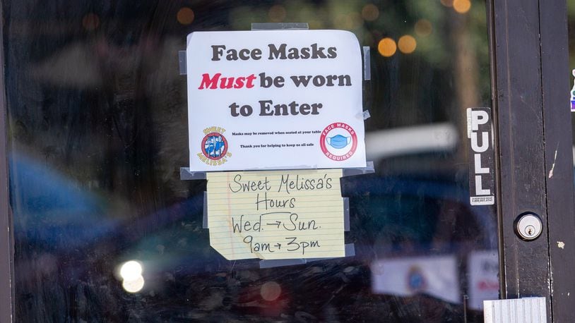 A sign requiring masks is taped to the door to the door of Sweet Melissa's in Decatur Monday, February 28, 2022.  STEVE SCHAEFER FOR THE ATLANTA JOURNAL-CONSTITUTION