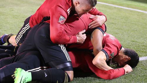 Atlanta United FC players pile on top of Yamil Asad after he scored the team’s first goal for a 1-0 lead against the N.Y. Red Bulls during the first game in franchise history on Sunday, March 5, 2017, in Atlanta. Curtis Compton/ccompton@ajc.com