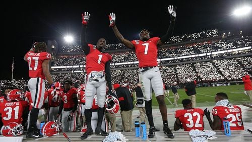 Georgia defensive backs Divaad Wilson (left) and Tyrique Stevenson signal the fourth quarter as fans light up Sanford Stadium during a 27-0 shut out over Missouri in a NCAA college football game on Nov. 9, 2019, in Athens.   Curtis Compton/ccompton@ajc.com