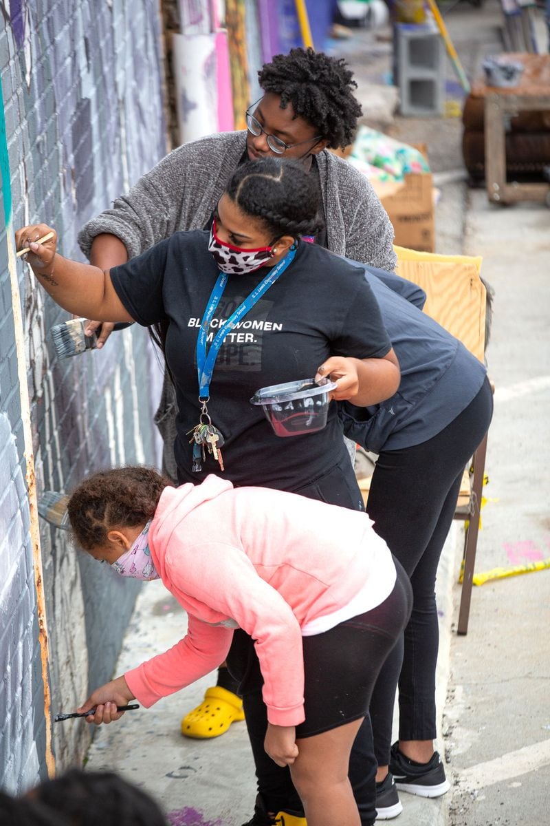  Volunteers from the neighborhood help fill in the details on the HEROINE Mural in Atlanta Saturday, September 19, 2020.  STEVE SCHAEFER / SPECIAL TO THE AJC 