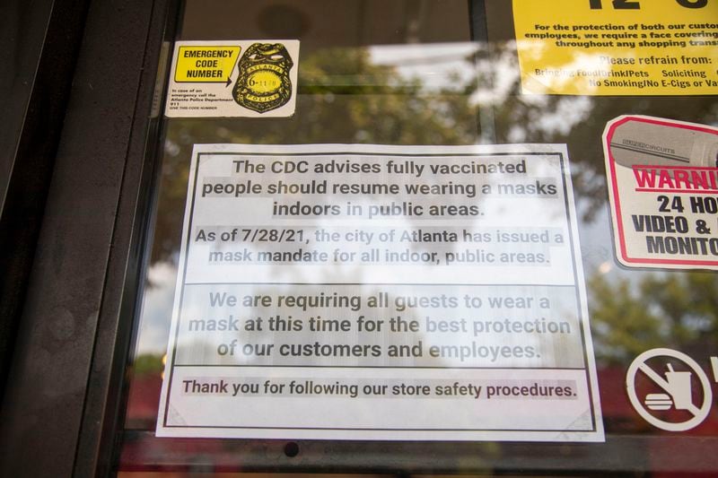 A sign asks customers to wear a mask at a shoe store in Atlanta’s Little Five Points community. A new order issued by Gov. Brian Kemp still allows businesses to require vaccinations or masks, but local governments cannot impose such restrictions on them. (Alyssa Pointer/Atlanta Journal Constitution)